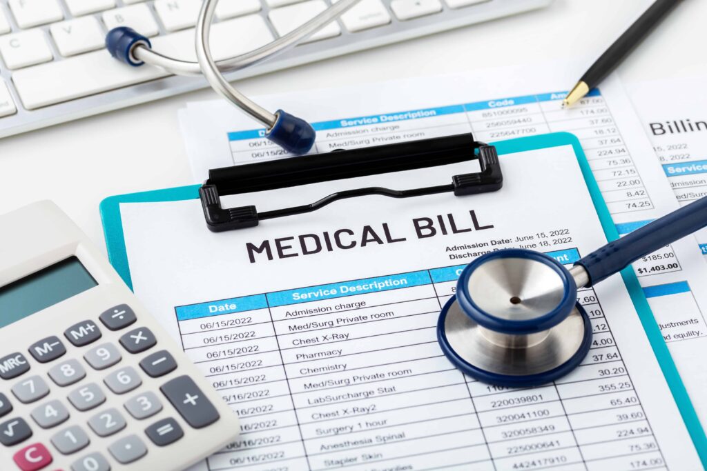 Medical bill statement with itemized healthcare charges, stethoscope, calculator, and paperwork on desk
