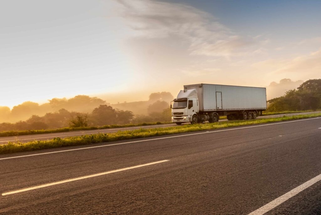 Semi truck driving on highway at sunrise, freight transportation and logistics concept