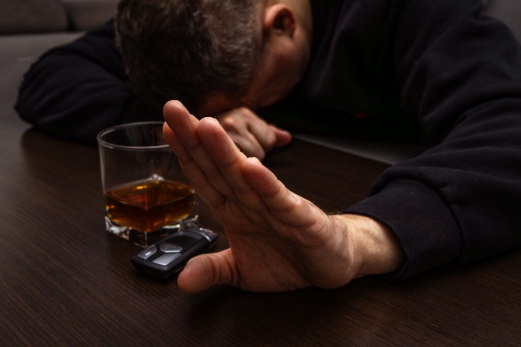 Intoxicated driver refusing more alcohol while sitting near car keys, illustrating Texas Dram Shop Law liability after a drunk driving accident