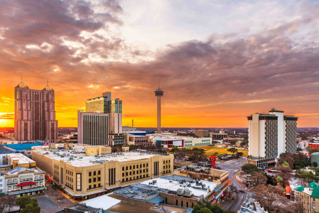 A high-angle view of the San Antonio, Texas skyline at sunset, representing the service area for Texas Uninsured Motorist Accident Lawyers.