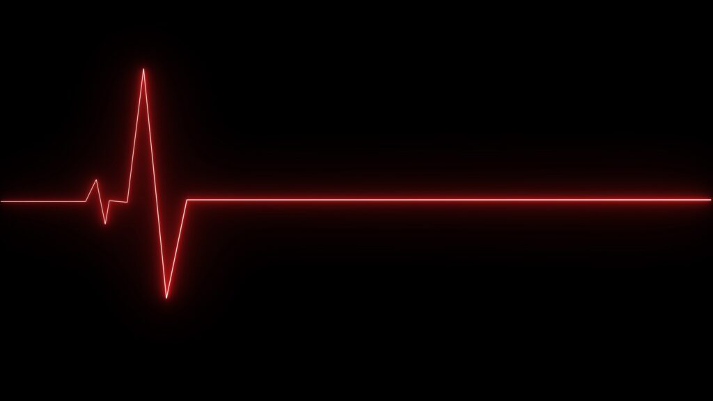 Red glowing electrocardiogram line showing a flatline reading on a black background.