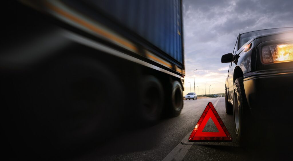 Warning reflector on road by semi-truck showing what evidence wins a San Antonio truck accident case.