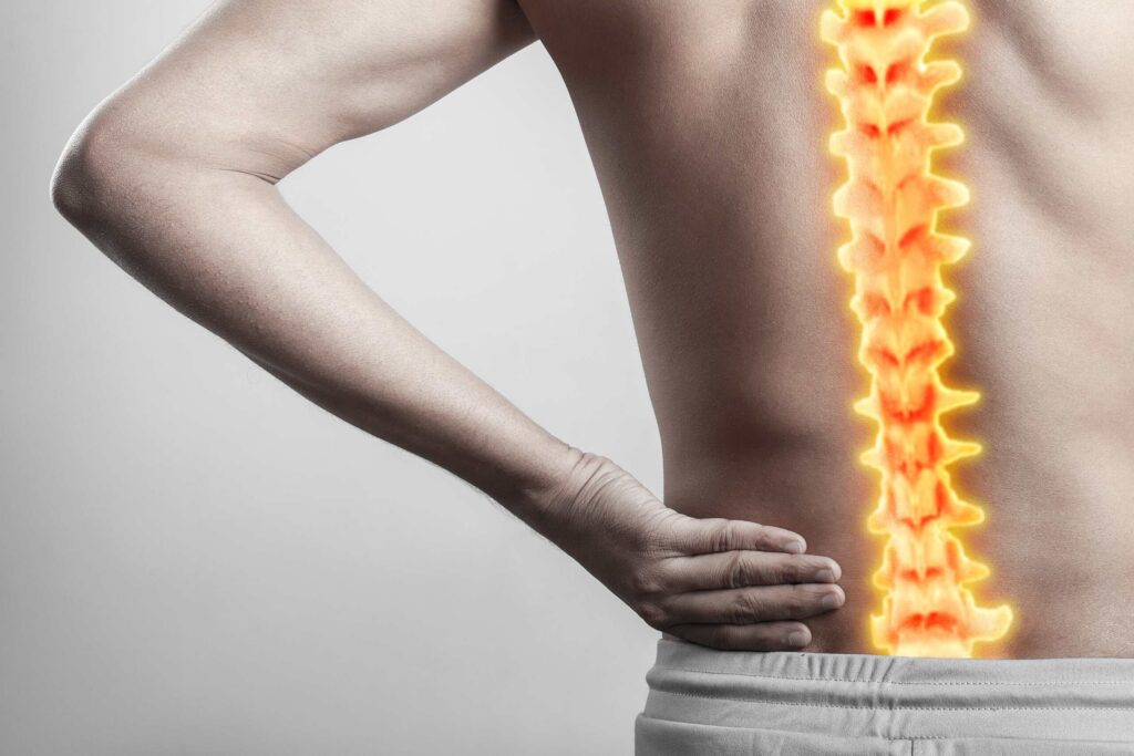 An image illustrating a highlighted spine with a hand on the lower back relates to understanding Texas Spinal Cord Injury Claims: What Compensation Covers.