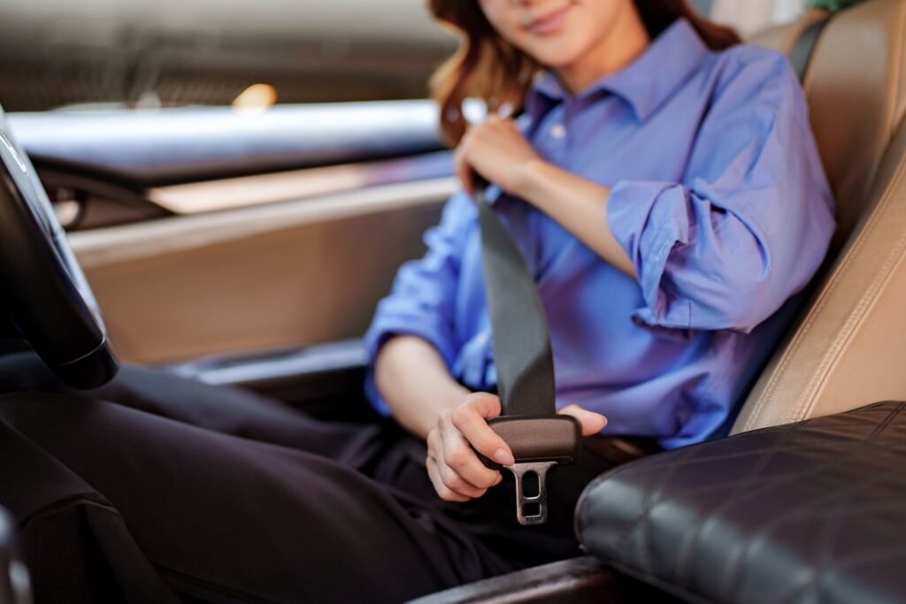Woman buckling her seat belt in a car, illustrating how Texas's seat belt defense can reduce your injury compensation.