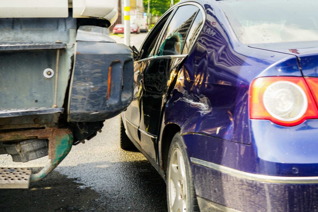 Commercial truck rear end impact with a blue passenger sedan detailing how long do you have to file a truck accident claim in Texas.