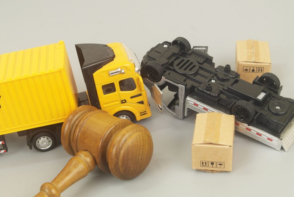 Toy trucks and cargo boxes next to a judge gavel illustrating how long do you have to file a truck accident claim in Texas.