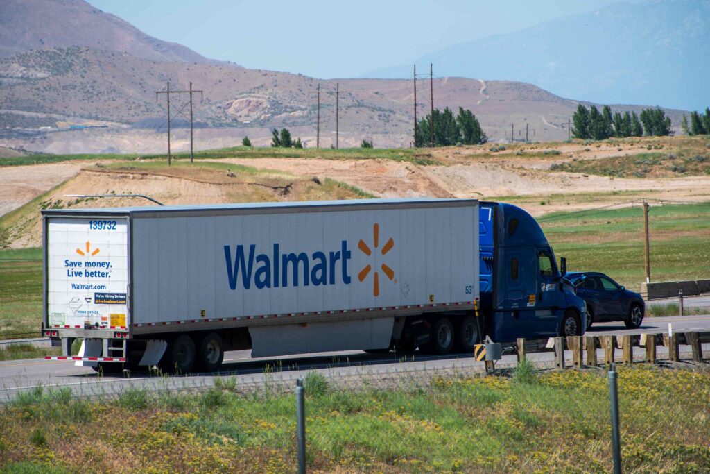 Large Walmart semi truck driving down a rural highway.